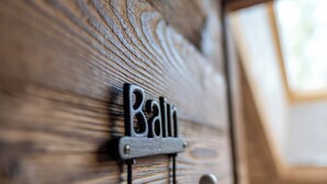 Um close-up de uma porta de madeira com uma placa de metal e um gancho.