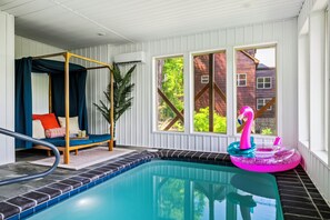Ein Poolbereich mit Whirlpool, einem Flamingo-Schwimmpfiff und einer Holzterrasse.