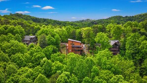 A forested area with multiple cabins. - Luxury Foliage Mtn Escape: Indoor Pool + Theater (Sevierville)