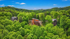 A forested area with multiple cabins. - Luxury Smoky Mtn Escape: Indoor Pool + Theater (Sevierville)
