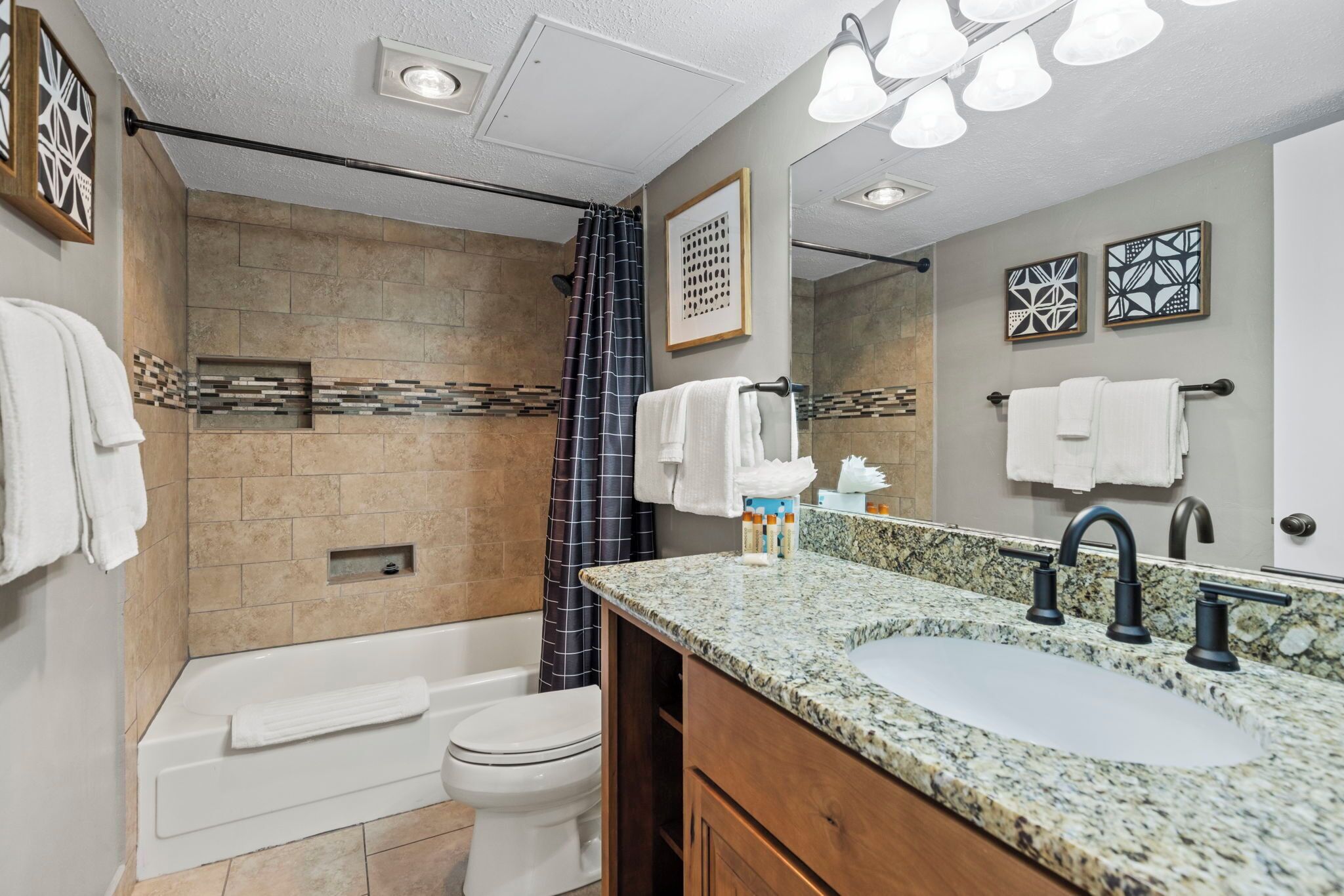 A modern bathroom with a bathtub, toilet, and sink.