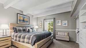 A bedroom with a large bed, bedside tables, a bench, a wardrobe, and a painting on the wall. - Columbine #301 (Breckenridge)