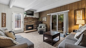 A cozy living room with a fireplace, a checkered armchair, and a sofa. - Columbine #301 (Breckenridge)