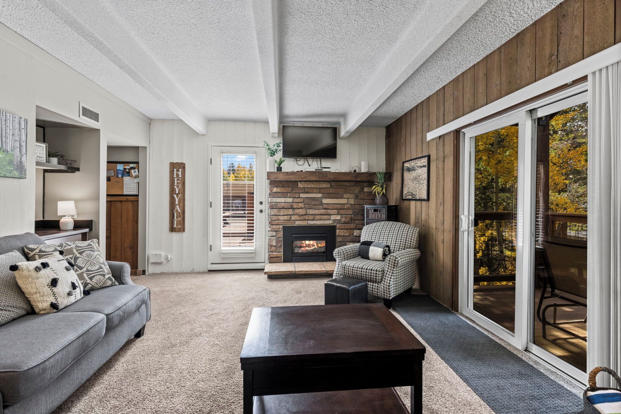 A cozy living room with a fireplace, a sofa, a coffee table, and a chair.