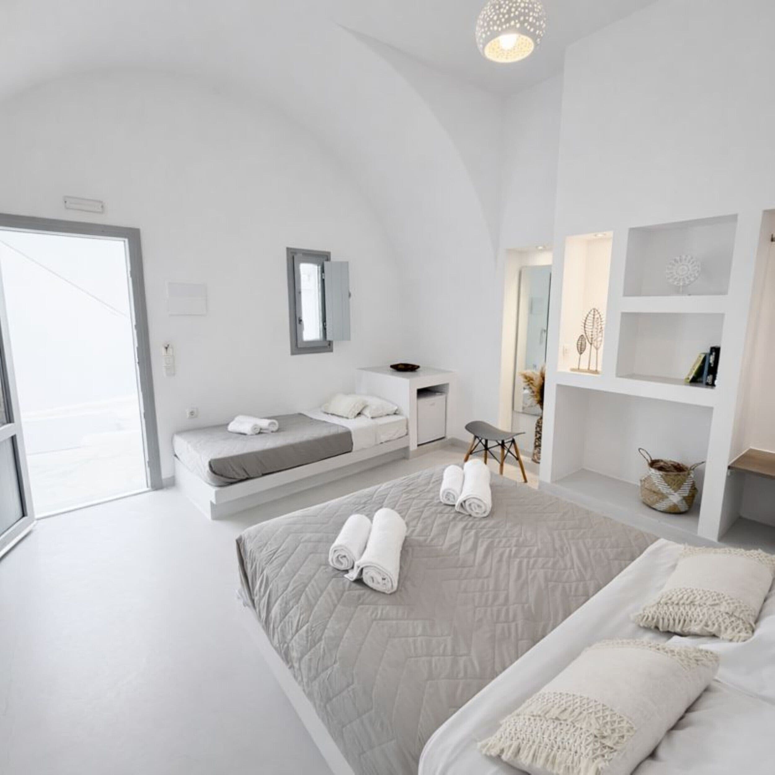 Un dormitorio moderno con una cama grande, un escritorio pequeño y un vestidor.