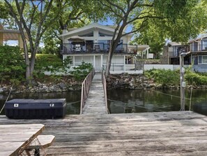 A wooden dock leading to a house with a balcony overlooking a body of water. - Lakefront Luxury w/ Dock, Great Location! (Vinita)