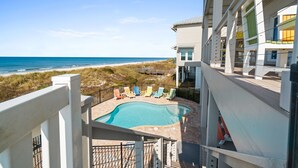 A pool area with lounge chairs and a view of the beach and ocean. - Seaside Seaesta- Gulf-front views and private pool (Port St. Joe)