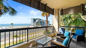 A balcony with wicker furniture and a view of the beach and ocean. - Club SeaLaVie- Family friendly, community pool, wifi (Mexico Beach)