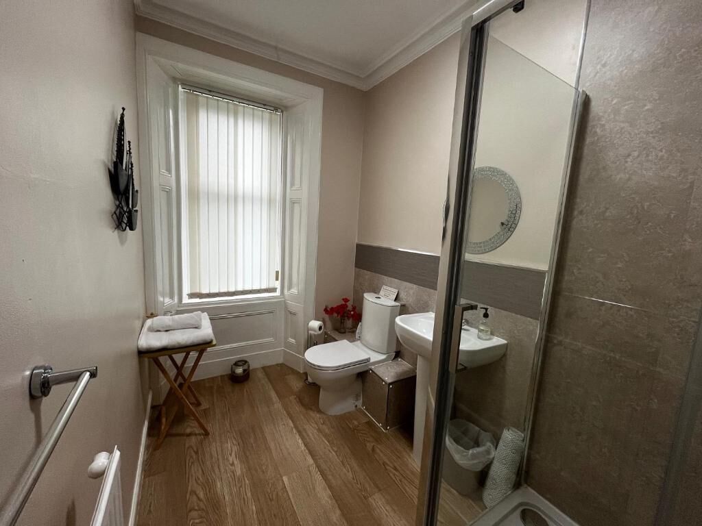 A bathroom with a toilet, sink, and shower.