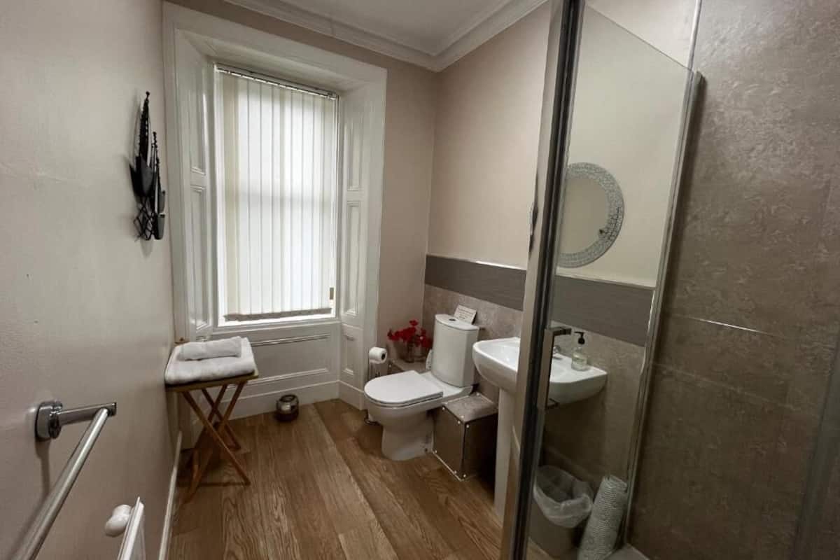 Un baño con inodoro, lavamanos y ducha.