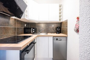 Eine moderne Küche mit Einbauherd, Mikrowelle, Spüle und Geschirrspüler.
