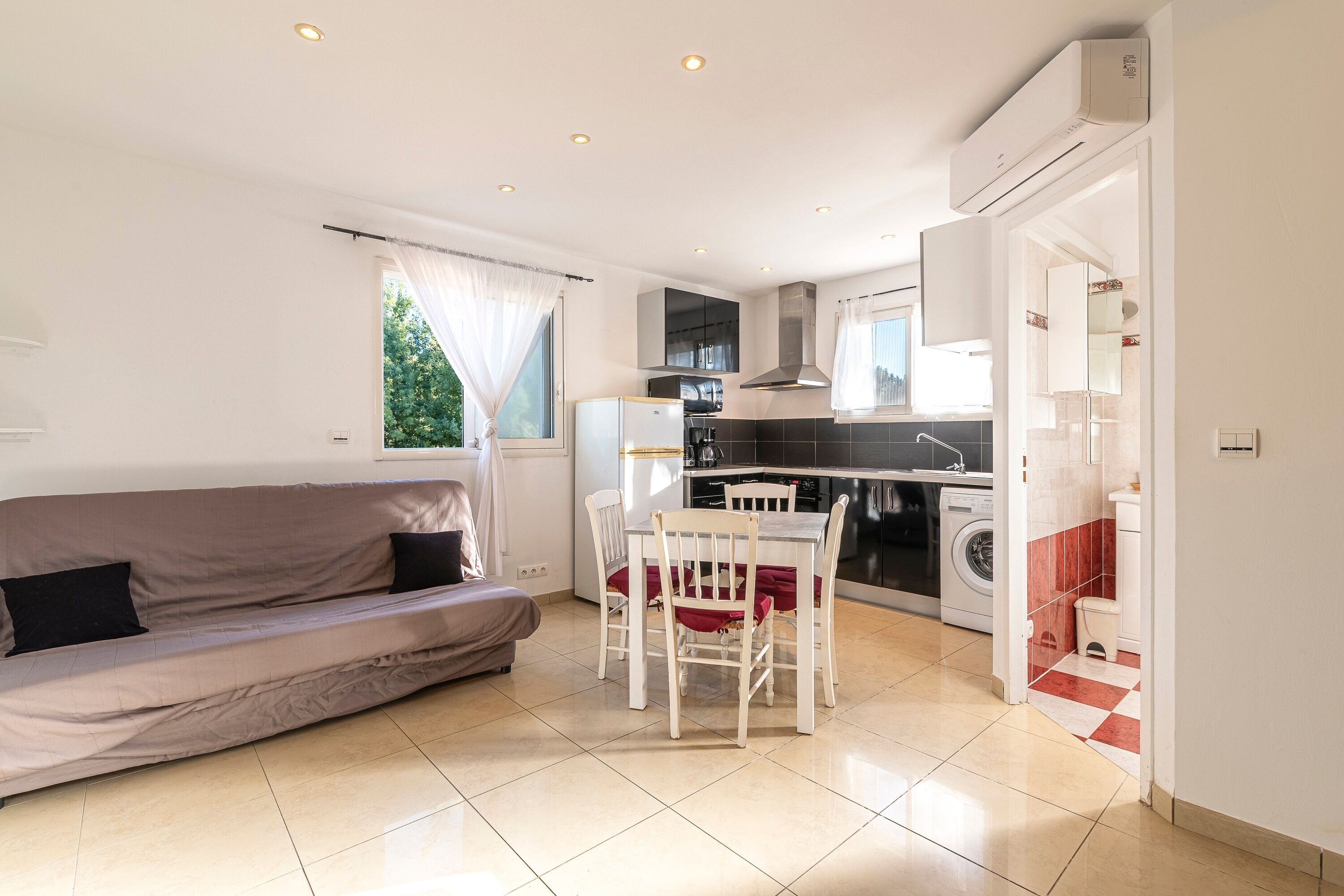 A compact living space with a sofa, dining table, and kitchenette.