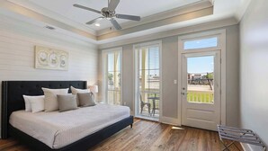 A bedroom with a bed, ceiling fan, and a view of the outside. - Huge New Home w/ Outdoor Space, Walk to Streetcar! (New Orleans)