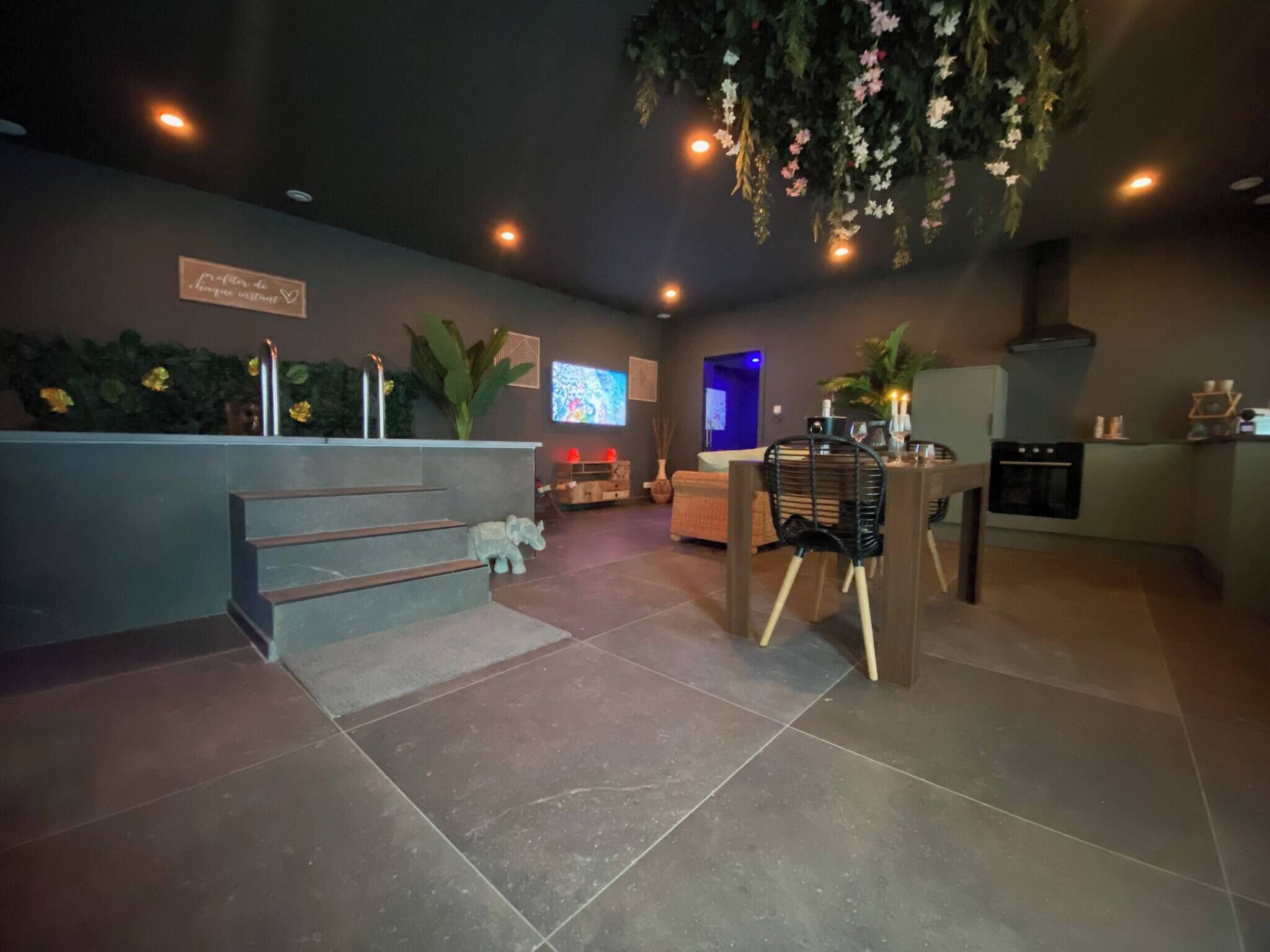 A modern interior with a reception desk, a staircase, a dining area, and a kitchen.