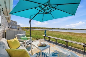 A deck with a turquoise umbrella, outdoor furniture, and a view of a lake. - Wonderland on the Water with Exclusive Beach Access (Biddeford)