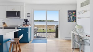 Una cucina moderna con un'ampia finestra, un'area pranzo con vista e un patio dotato di barbecue.