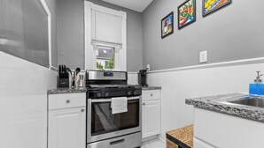 Une cuisine moderne avec des meubles blancs, une cuisinière en acier inoxydable et un plan de travail en granit.
