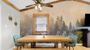 A dining area with a wooden table, two chairs, a ceiling fan, and a window with blinds. - Family Retreat w/ Hot Tub near Zoo & Forest Park (St. Louis)