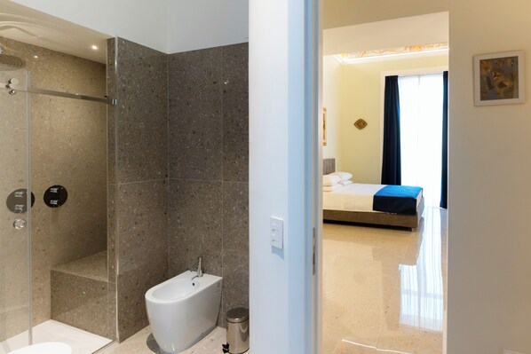 Une salle de bain moderne avec une douche à parois de verre, une baignoire sur pieds et des toilettes.