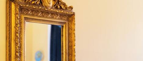 A gold-framed mirror with ornate designs.