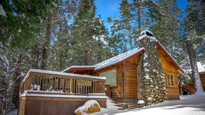 A log cabin with a stone foundation, wooden deck, and a sign that reads "Grans Z Cabin." - Chipmunks Holiday (Yosemite National Park)