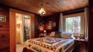 A cozy cabin room with a bed, a nightstand, a window with curtains, and a wooden ceiling. - Chipmunks Holiday (Yosemite National Park)