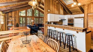Een gezellig chalet van binnen met een eethoek, keuken en een slaapvide met dakraam.