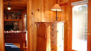 A wooden interior with a foosball table, a lamp, and a stone fireplace. - Black Oak Lodge (Yosemite National Park)