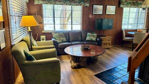 A cozy living room with a sofa, armchairs, a coffee table, and a TV. - Heart of the Meadow (Yosemite National Park)