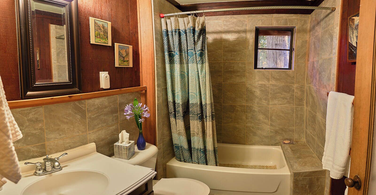 A bathroom with a bathtub, a sink, and a mirror.