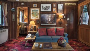 A cozy room with a blue sofa, a wooden coffee table, and a framed map on the wall. - Chipmunk Hollow (Yosemite National Park)