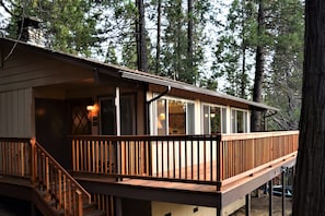 A cabin with a wooden deck, large windows, and a chimney. - Sequoia House (Yosemite National Park)
