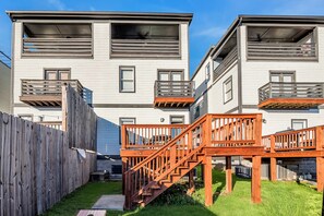A modern multi-story residential building with balconies, wooden staircases, and a wooden fence. - Nashville home with game room, 3 balconies & backyard, sleeps 12 (Nashville)