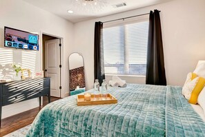 A bedroom with a bed, a bedside table, a TV, and a window with curtains. - Nashville weekend house with hot tub, karaoke & game room, sleeps 12 (Nashville)