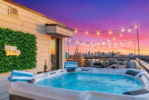 A rooftop terrace with a hot tub, string lights, and a city skyline view. - Nashville bachelorette house with hot tub, karaoke stage & game room, sleeps 13 (Nashville)