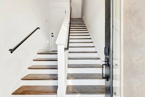 A staircase with wooden steps and a metal handrail. - Nashville hot tub & karaoke game room home, sleeps 13, 4 bedrooms (Nashville)