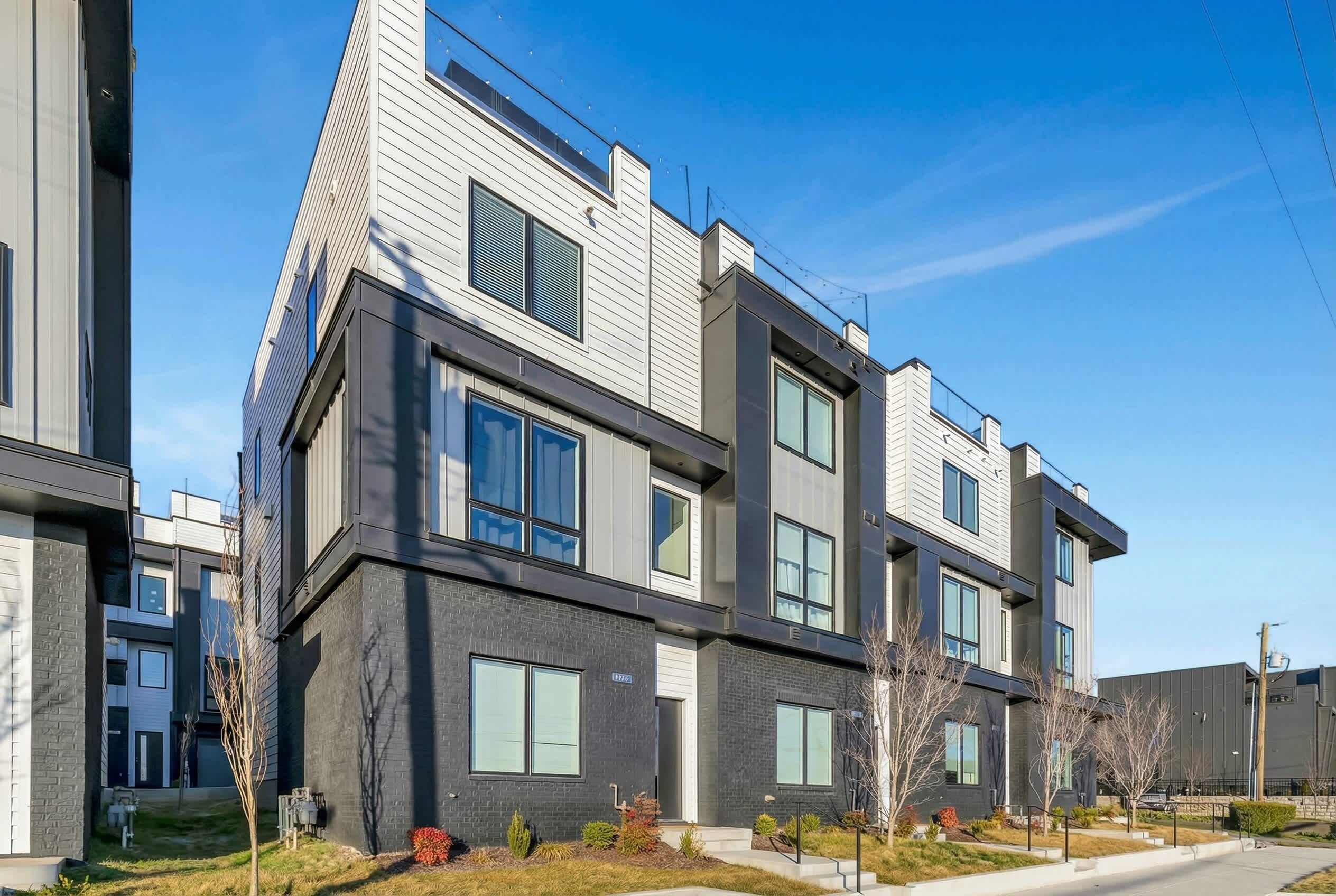 A modern multi-story residential building with large windows and a flat roof.