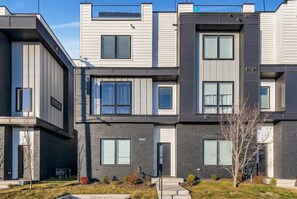 A modern multi-story residential building with a mix of white and dark gray exterior walls, large windows, and a small tree in the front yard. - Nashville weekend house with hot tub, karaoke & game room, sleeps 12 (Nashville)