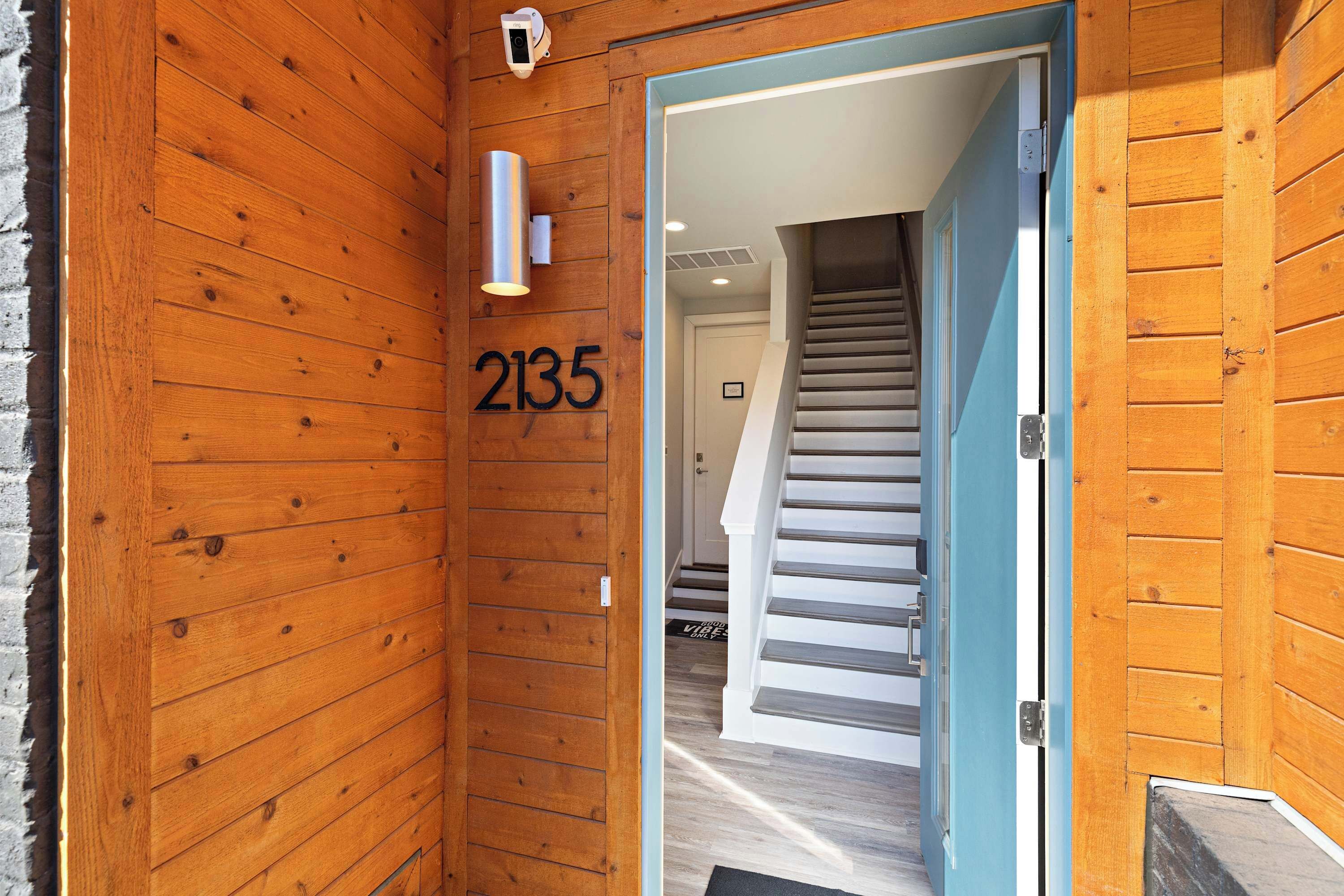 A wooden exterior wall with a number '2135' indicating the property number.