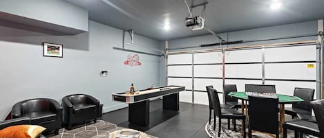 A modern indoor space with a pool table, comfortable seating, and a billiards table.