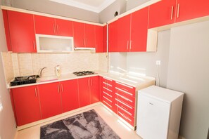Apartamento família, sacada, vista para a cidade | Cozinha privada | Frigobar, cooktop, talheres/pratos/utensílios de cozinha