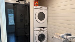 A compact laundry room with a washing machine, dryer, and toilet.