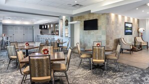 A hotel lobby with a bar area, seating arrangements, and a television mounted on the wall. - 1-Bedroom Villa Near Disney w/ Pool & Lazy River (Kissimmee)