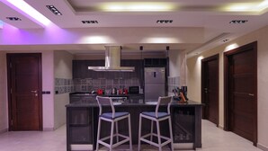 Una cucina moderna con isola centrale, sgabelli da bar ed elettrodomestici integrati.
