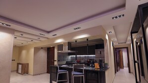 Una cucina moderna con isola centrale, sgabelli da bar ed elettrodomestici integrati.