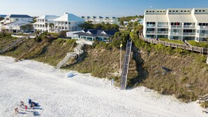 A coastal hotel with multiple buildings, a sandy beach, and a wooden boardwalk leading to the beach. - Hidden Pines Sanctuary - Bungalow Escape Near 30A (Santa Rosa Beach)