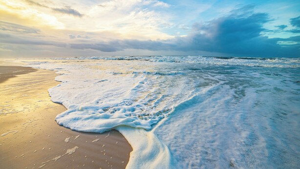 A beach with waves gently lapping onto the shore under a partly cloudy sky. - Hidden Pines Sanctuary - Bungalow Escape Near 30A (Santa Rosa Beach)