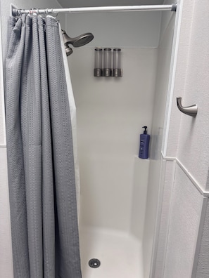 Chuveiro, toalhas de banho, papel higiênico