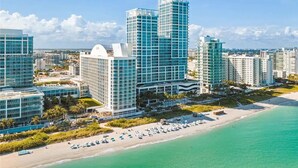 A high-rise hotel with multiple floors, a beachside location, and a view of the ocean. - 1BR Oceanfront Resort with pool (Miami Beach)