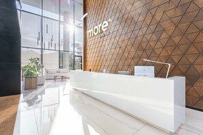 Una taulell de recepció modern amb un mur amb un disseny geomètric i una partició de vidre.